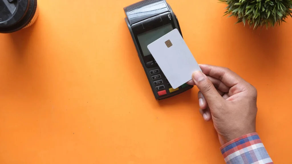 A person tapping a credit card on a contactless payment terminal