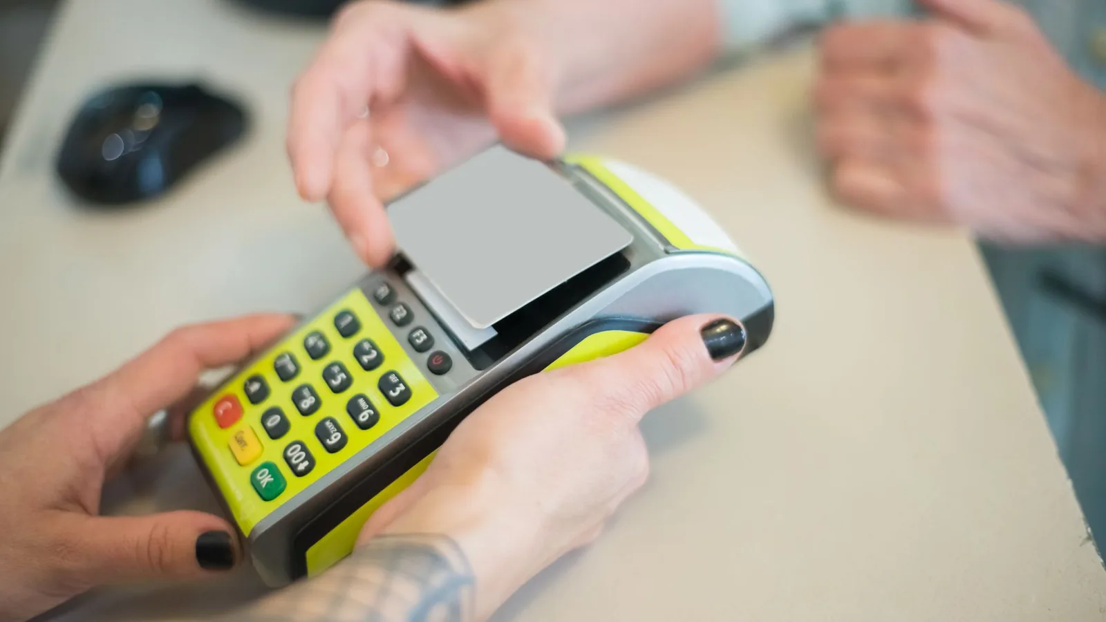 Hands engaging in a secure card transaction with a payment terminal, capturing the essence of modern business transactions.