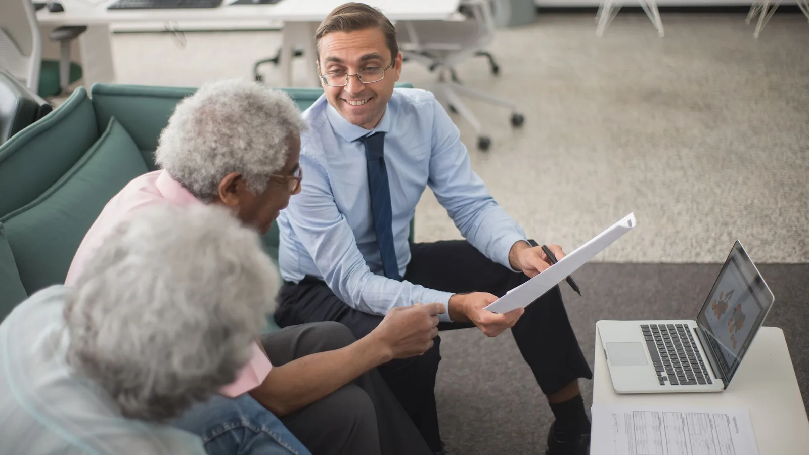 An insurance consultant going through policy documents with a couple