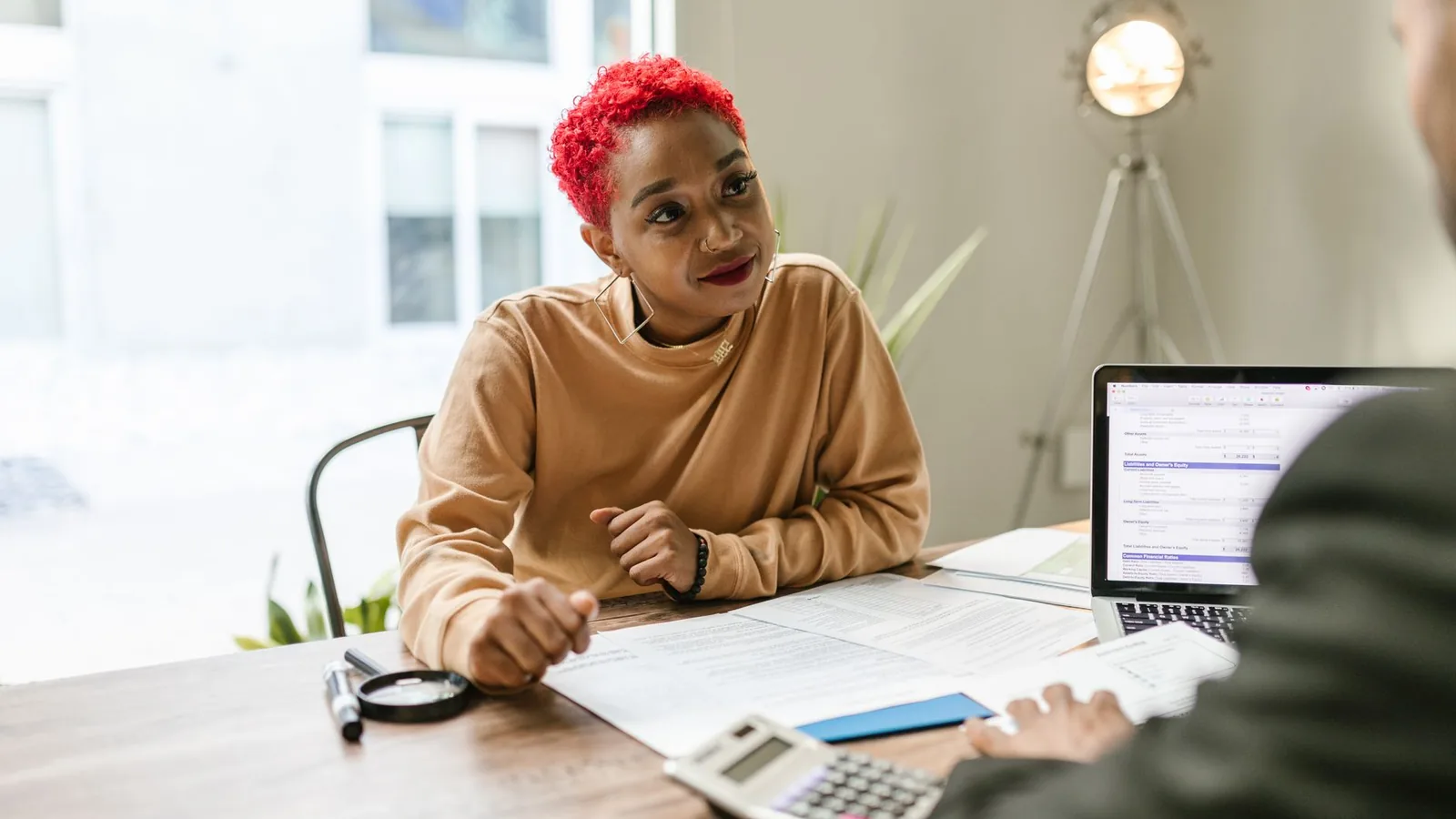 Professional woman engaged in thoughtful discussion at a business meeting indoors.